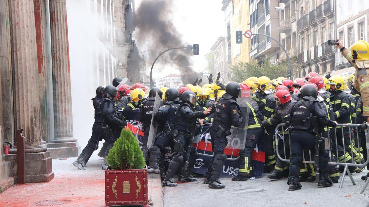 Momento de la carga policial tras la acometida de los bomberos.