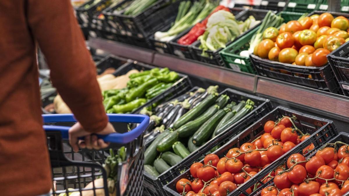 Un home passa per davant de l’espai de les verdures en un supermercat