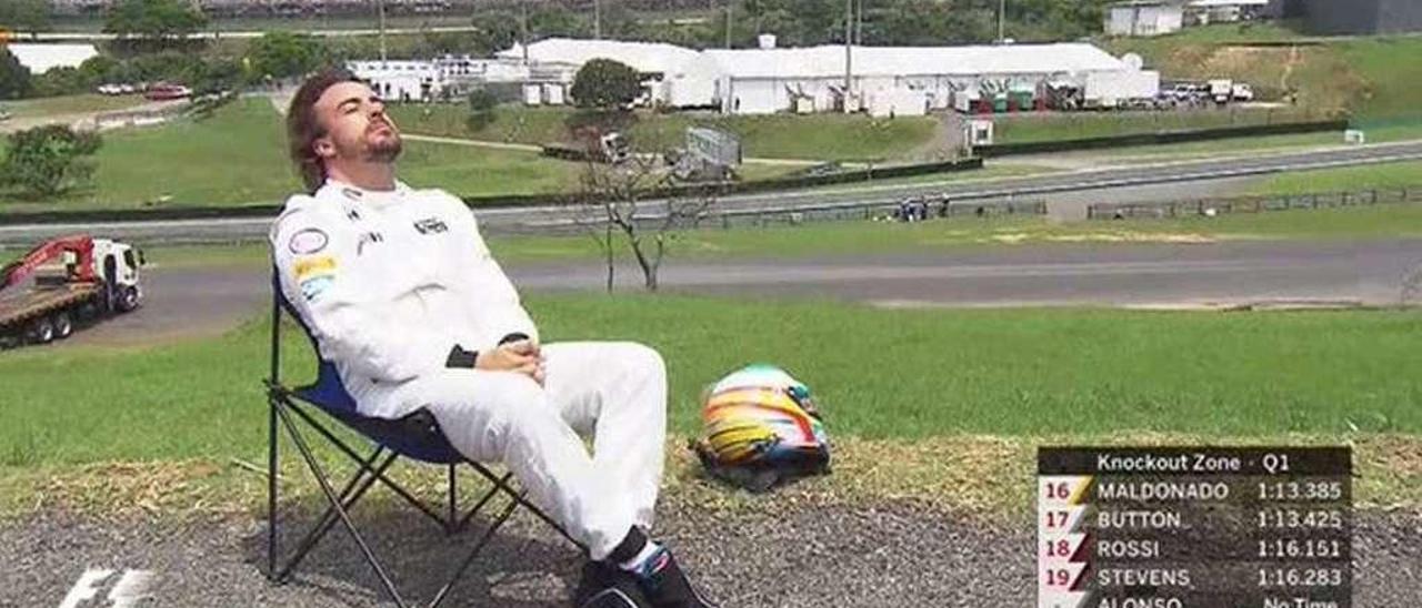 Fernando Alonso toma el sol en Interlagos tras la avería de su McLaren en la sesión de clasificación en 2015.