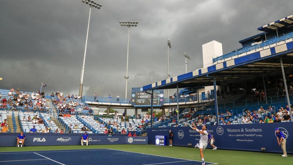 Nubes grises sobre las canchas mientras el tenista francés Adrian Mannarino responde un tiro del austríaco Dominic Thiem