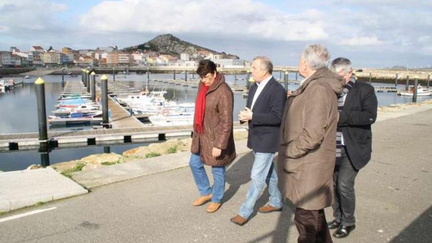 Desde la izda., Marisol Soneira, Manuel Vázquez, Méndez Romeu y Félix Porto, ayer, delante del puerto. / l. o.