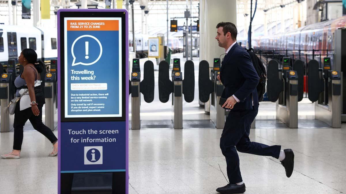 Un pasajero corre para tomar un tren en la estación de Waterloo antes de que el servicio de trenes termine temprano, en el primer día de la huelga ferroviaria nacional en Londres, Gran Bretaña, el 21 de junio de 2022. REUTERS/Henry Nicholls