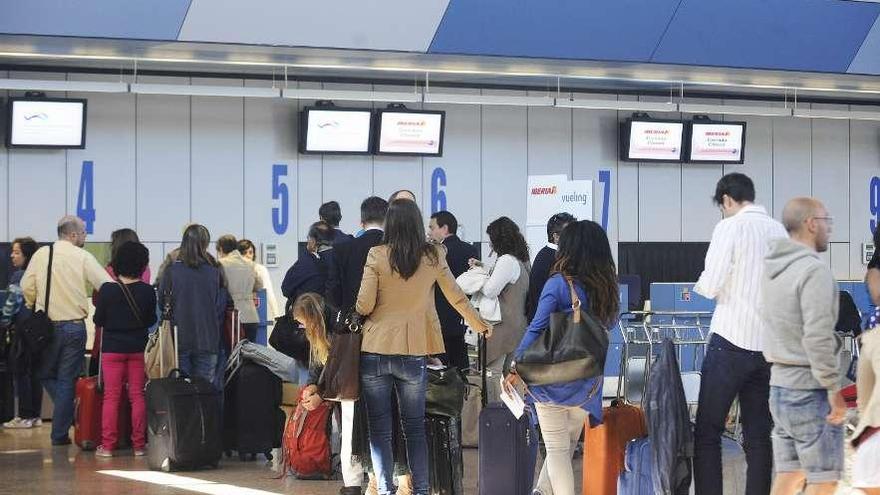 Cola de pasajeros a la espera de facturar en Alvedro. 13fotos