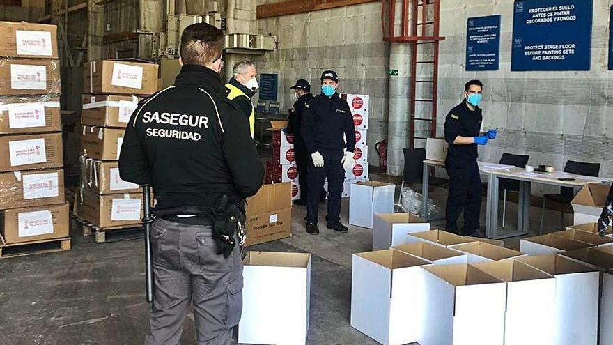 Personal de seguridad y de la Generalitat preparando lotes de material para distribuir.