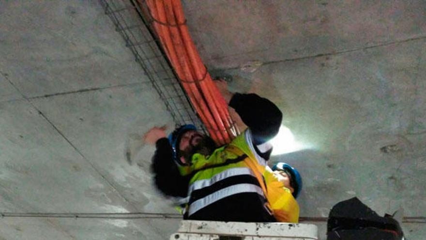 Operarios trabajan en el cableado del túnel.