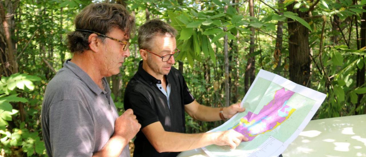 Carlos Corominas i Joan Rovira mirant el mapa de la superfície forestalon no pot fer el canvi d’espècie   | MARINA LÓPEZ/ACN