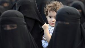 A boy looks as he and women supporters of the Houthi movement attend a rally held to celebrate following claims of military advances by the group near the borders with Saudi Arabia, in Sanaa, Yemen October 1, 2019. REUTERS/Khaled Abdullah