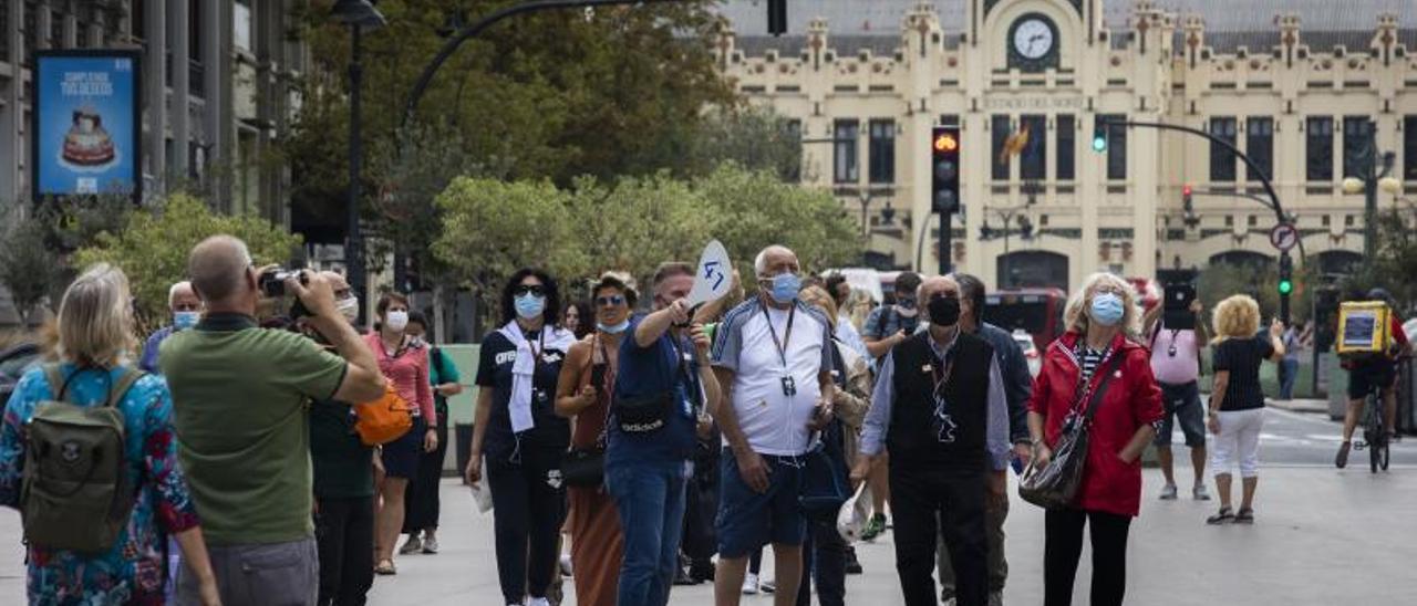 Un guía muestra la plaza del Ayuntamiento a un grupo de turistas.  | G. CABALLERO