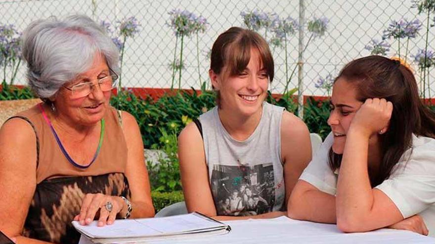 Rapazas integrantes do Proxecto Pesquedellas, aprendendo cancións e o traballo do lagar, con Carmiña.