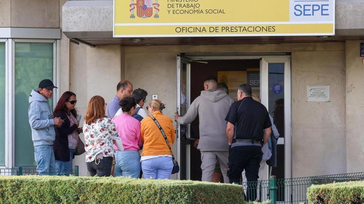 Varias personas en la entrada de una oficina del SEPE
