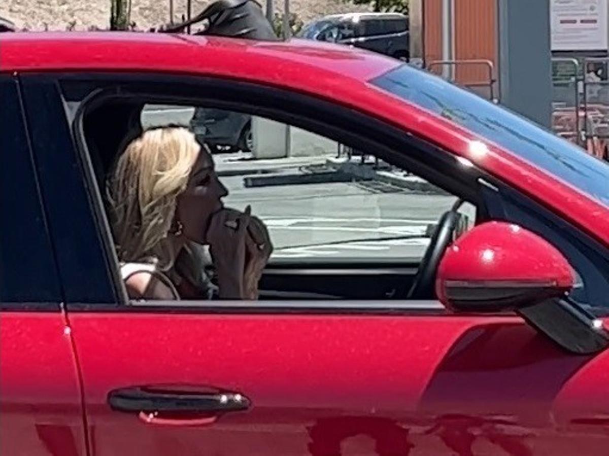 Carmen Lomana comiéndose una hamburguesa en su coche.