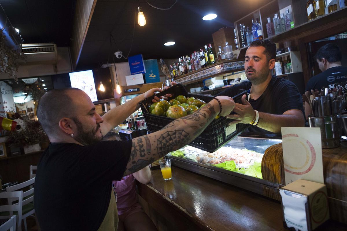 Dos trabajadores de un local, durante unas pasadas Hogueras.