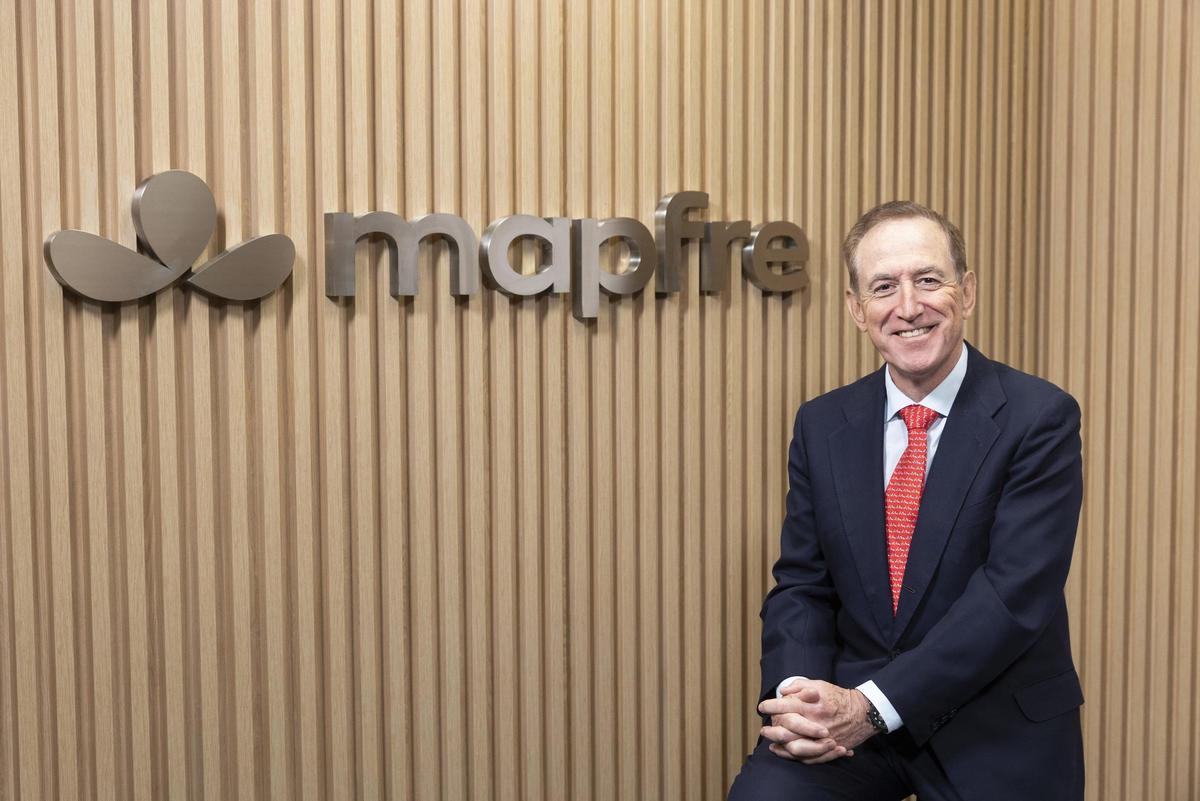 El presidente de Mapfre, Antonio Huertas, junto a la nueva identidad de Mapfre.