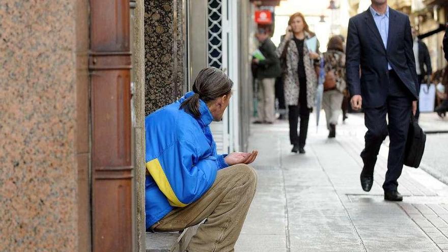 Un hombre pide en la calle en el centro de Pontevedra. // Rafa Vázquez