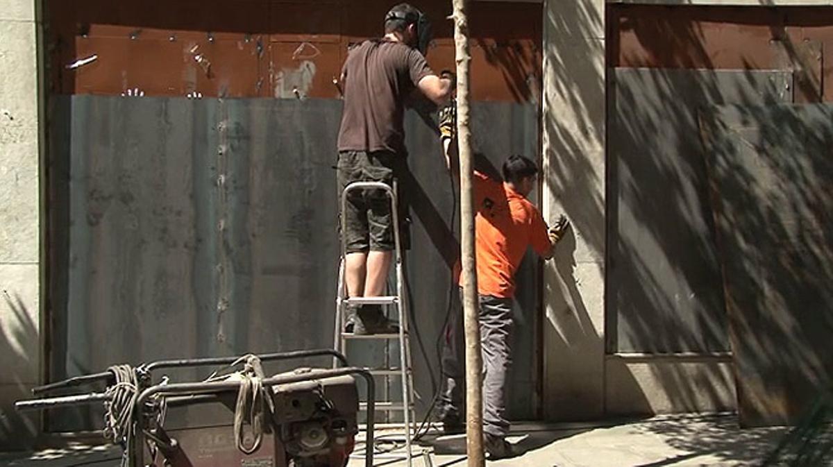 Operaris reforcen el local del banc expropiat amb més planxes metàl·liques