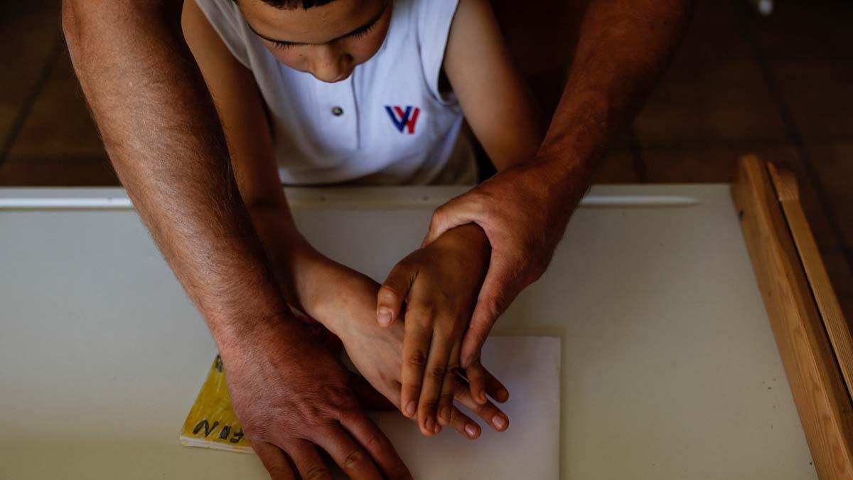 Alberto Toro ayuda a Youssef el Hadri, de 9 años, a comenzar a hacer un libro durante una clase en el pequeño pueblo español de Pitarque en Teruel, una de las regiones menos pobladas de la Unión Europea. Solo cuatro niños mantuvieron abierta la escuela en el pueblo remoto, pero con dos de ellos saliendo al final del año escolar, la escuela tendrá que ser cerrada. Está emocionado de poder pasar tiempo con más niños de su edad, pero dice que extrañará a su maestro, Alberto Toro. Toro ha pasado los últimos 14 años enseñando aprendizaje basado en el pensamiento e inteligencia emocional a los últimos niños criados en Pitarque. 