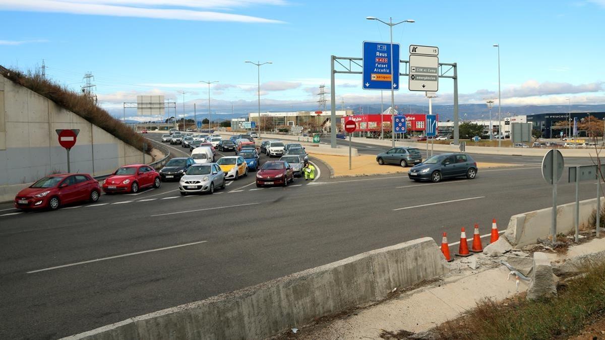 Accidente en Les Gavarres en la T-11 a Tarragona con retenciones de vehículos y la señal del impacto destrozada por un vehículo.