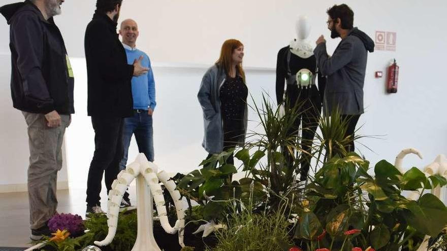 La instalación &quot;The Plants Sense&quot;, en primer término, ayer, con Alberto Valverde y María Castellanos (primero y cuarta por la izquierda) en el vestíbulo de Laboral Centro de Arte.