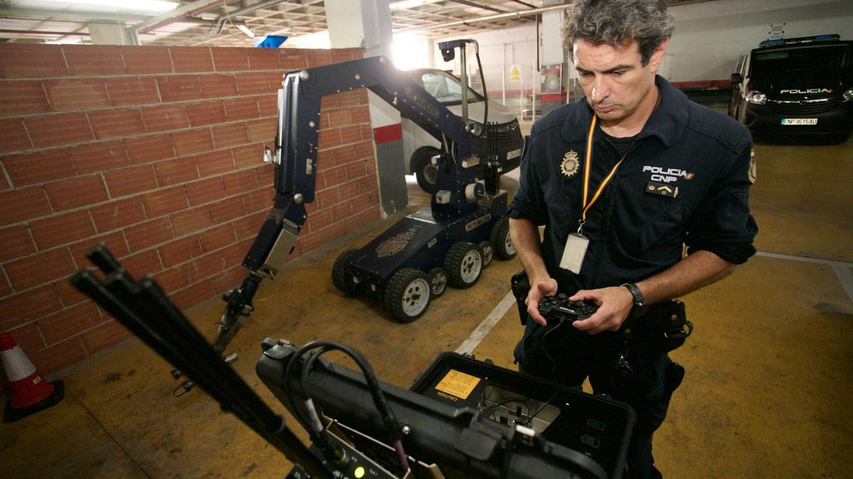 El subinspector Javier Tortosa, a los mandos para manejar el robot, tras de sí, en las dependencias policiales de Sangonera.
