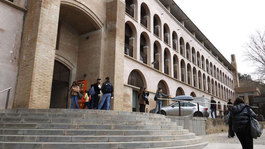 La porta de la Facultat de Lletres de la UdG amb alguns estudiants parlant als afores