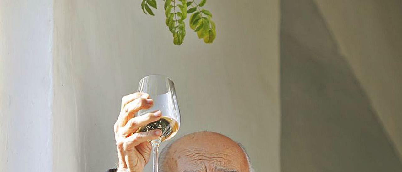 Francisco Brines, desde el balcón de su casa, brinda con vino.