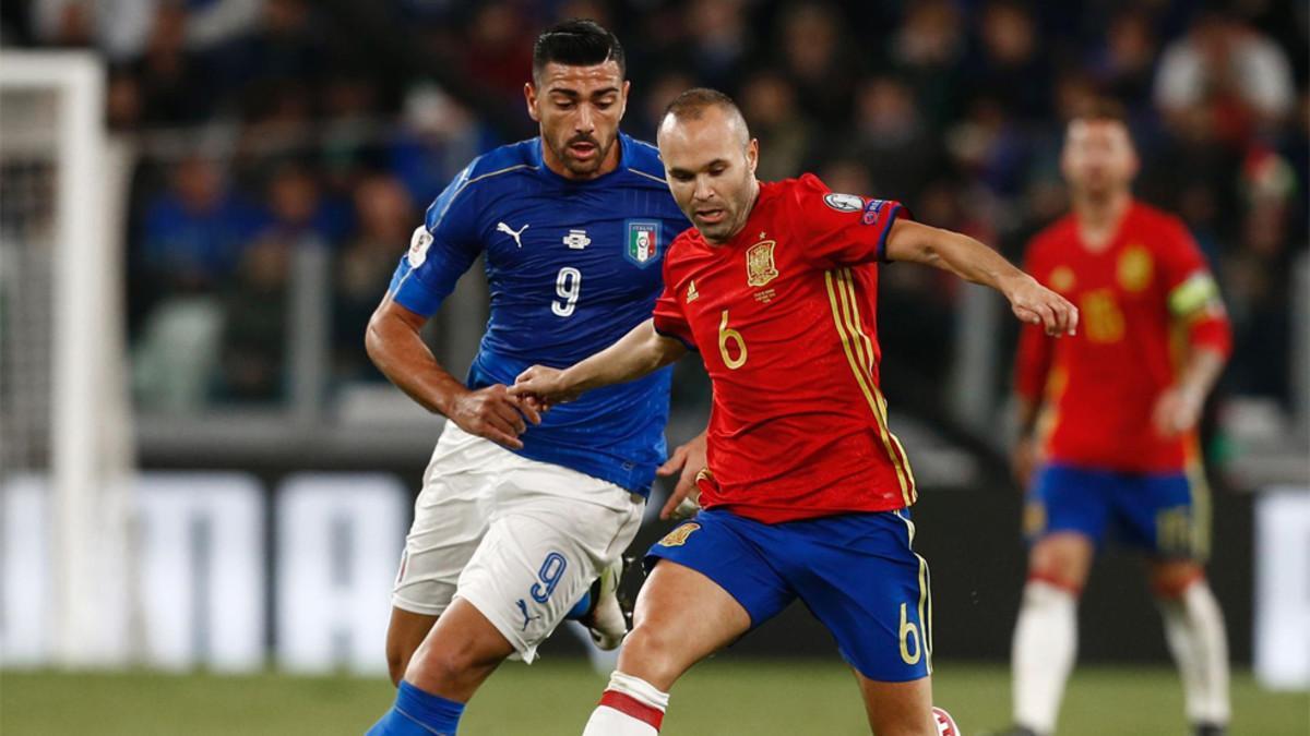 Andrés Iniesta con el delantero Graziano Pelle en el Italia-España de clasificación para el Mundial Rusia 2018