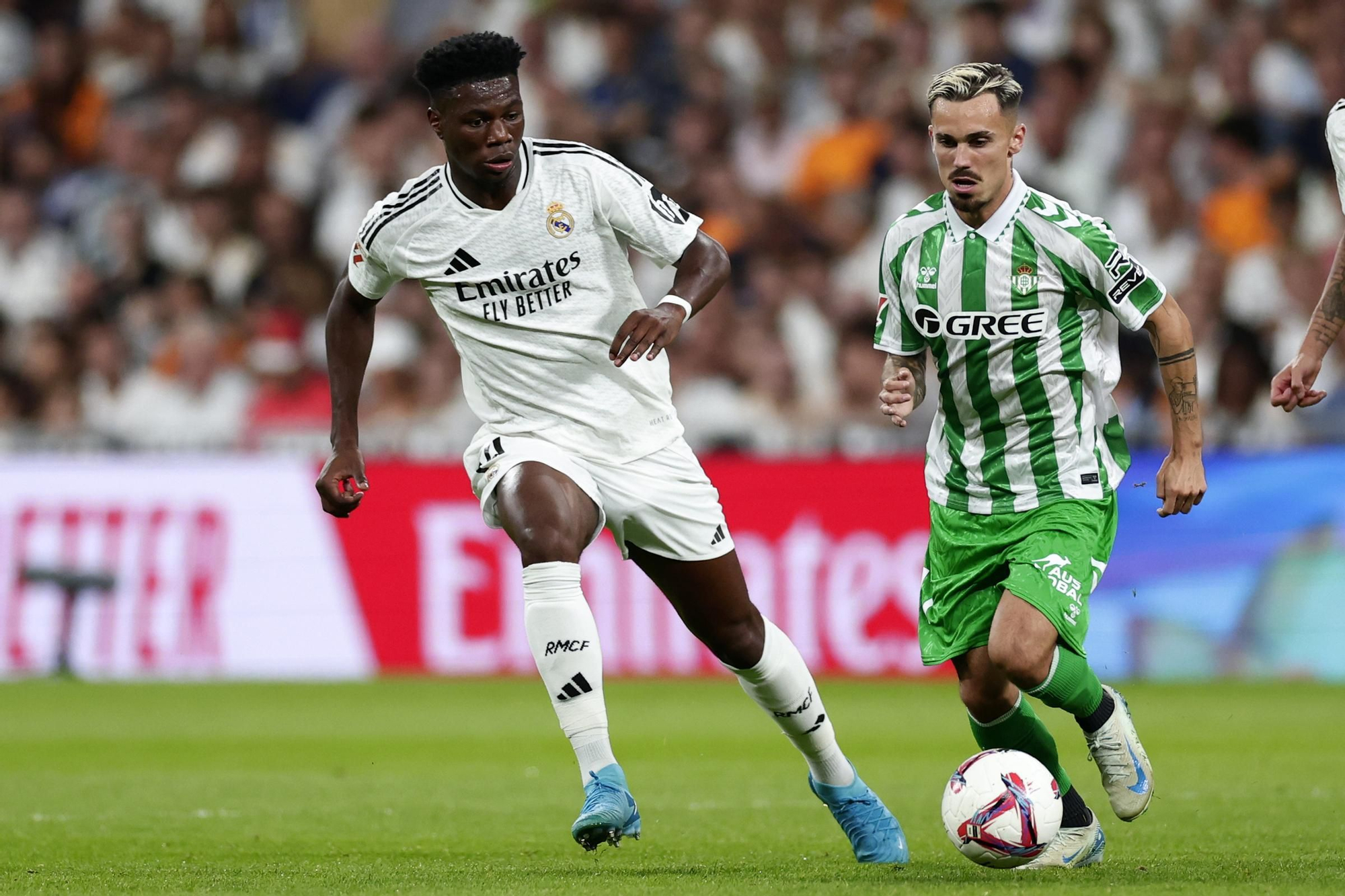Real Madrid's Aurelien Tchouameni, left, challenges Betis' Pablo Fornals during the Spanish La Liga soccer match between Real Madrid and Betis at the Santiago Bernabeu stadium in Madrid, Spain, Sunday, Sept. 1, 2024. (AP Photo/Pablo Garcia)
