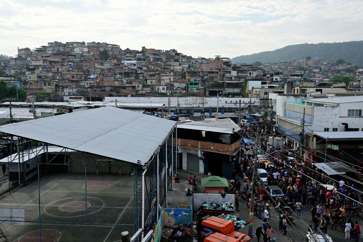 EDITORS NOTE: Graphic content / Residents stand next to lined-up bodies on Sao Lucas Square of the Vila Cruzeiro favela at the Penha complex in Rio de Janeiro, Brazil, on October 29, 2025, in the aftermath of Operacao Contencao (Operation Containment). Residents of a favela in Rio de Janeiro lined up more than 50 bodies at a plaza in their low-income neighborhood on Ocotber 29, a day after the bloodiest police operation in the citys history, AFP reported. (Photo by Pablo PORCIUNCULA / AFP). Graphic content