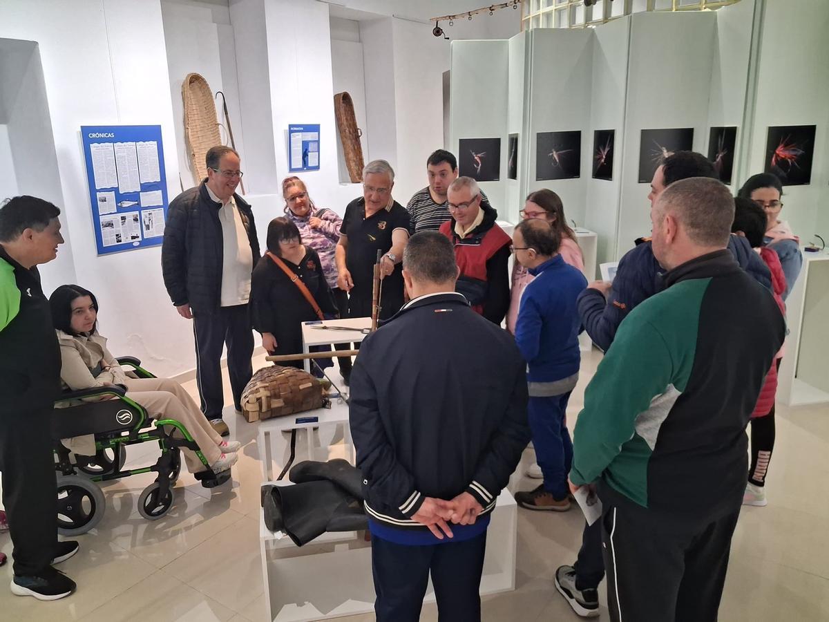 Manuel "Loli" Fidalgo, en el centro, explica a los usuarios el material de la exposición.
