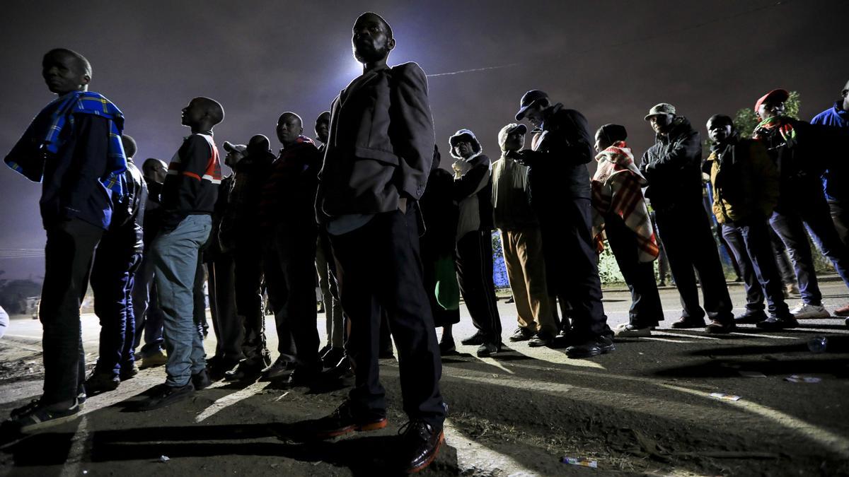 Votantes hacen cola esperando la apertura de puertas en la jornada electoral.