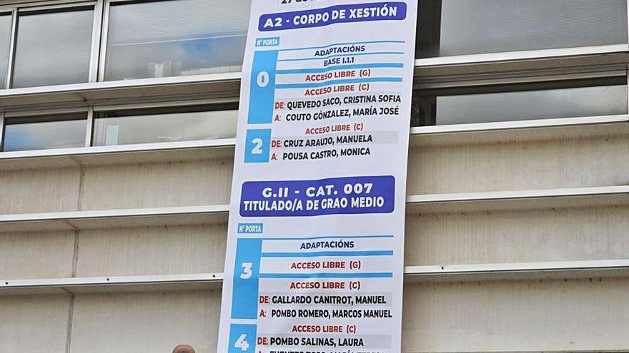 Dos operarios, colocando el cartel informativo.   | // FERNANDO CASANOVA