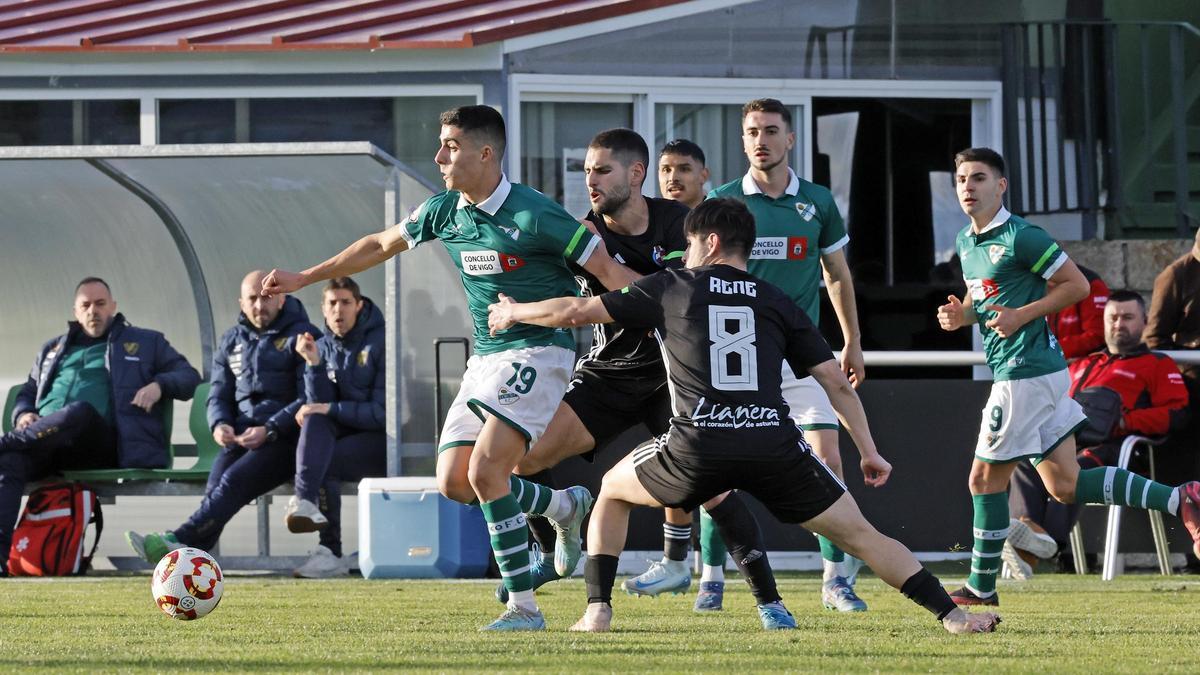 Hugo Rodri, del Coruxo, intenta sacarse de encima la presión de René durante el partido de ayer en el campo de O Vao