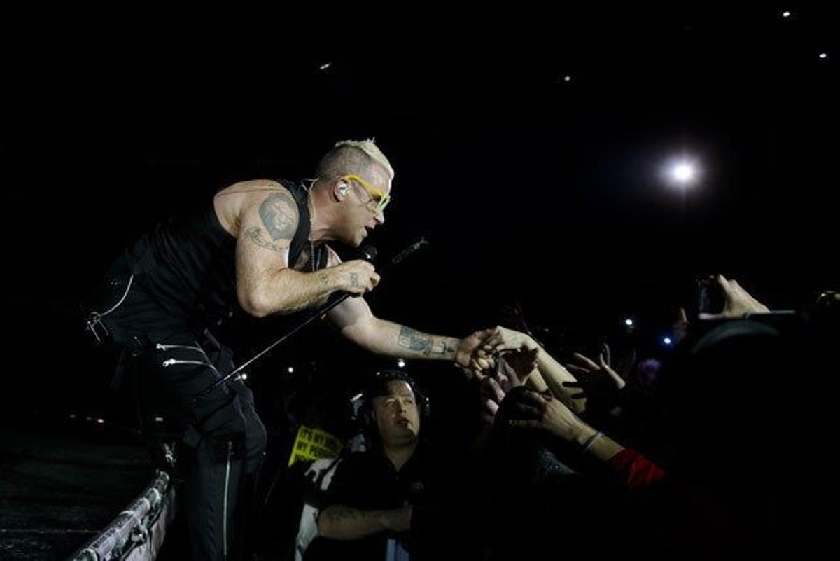 Robbie Williams saludando a los fans más cercanos al escenario