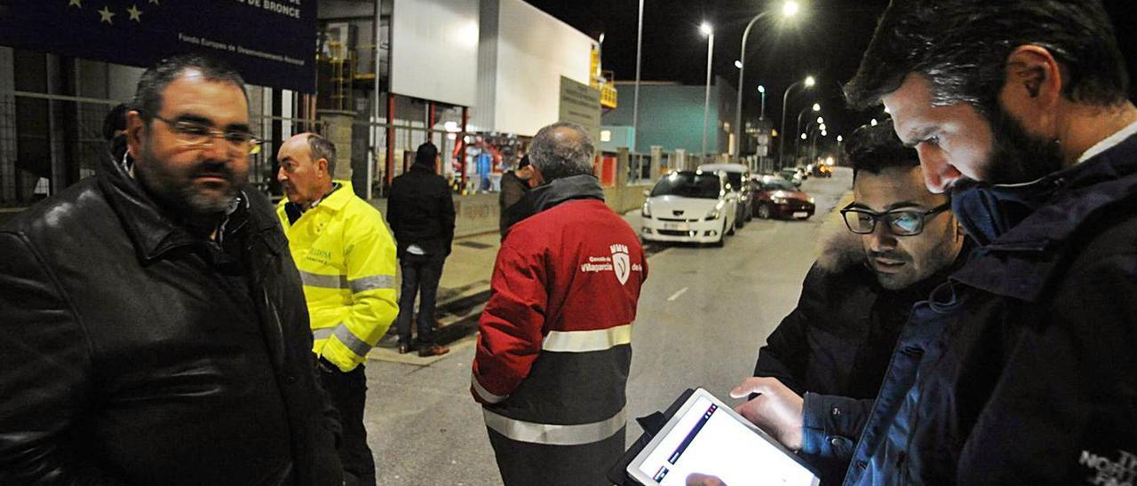 El alcalde, Alberto Varela, prueba con una tableta digital el nuevo alumbrado de O Pousadoiro.  | // IÑAKI ABELLA