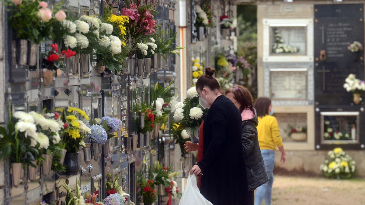 En el Día de Todos los Santos, las familias acuden a honrar a sus muertos con flores y velas.