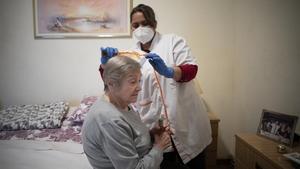 Barcelona 25 11 2020 Acompanamos a Grey Escorcia   una trabajadora del Servicio de Atencion a Domicilio (SAD) del Ayuntamiento de Barcelona que atiende a personas con dependencia que viven solas y que necesitan apoyo para tareas domesticas En la foto con Paquita Salat FOTO de FERRAN NADEU