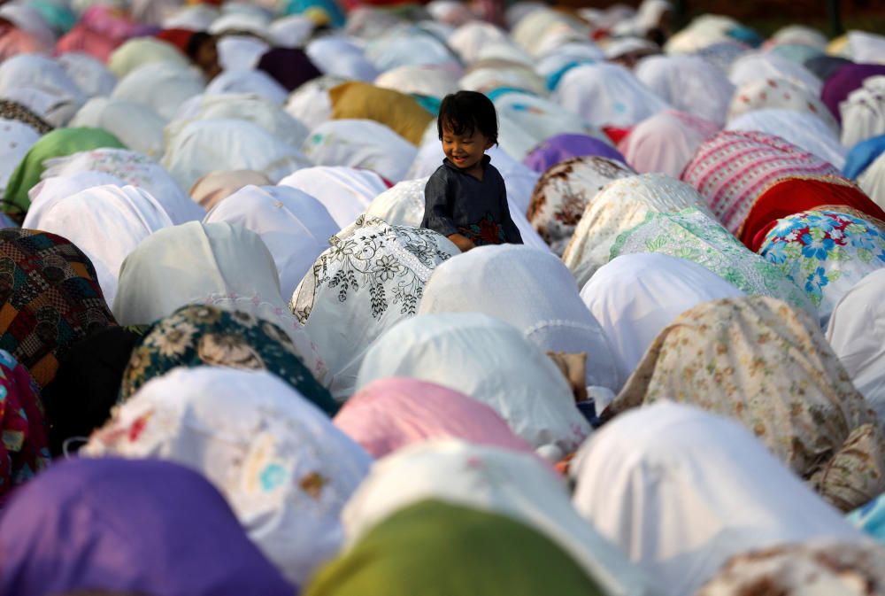 People attend prayers for the Muslim holiday of ...