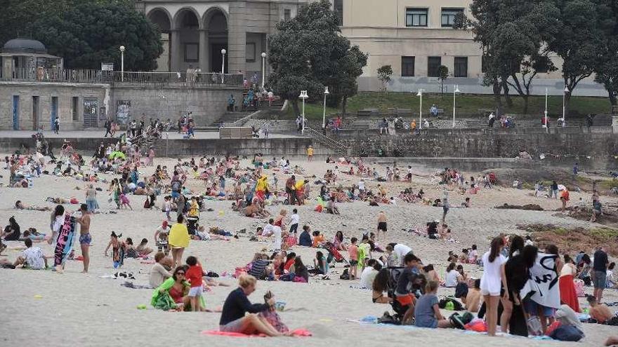 Gente disfrutando del sol de estos días en la playa de Riazor.