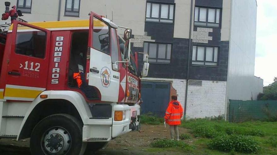 Efectivos de seguridad ante el edificio afectado ayer por un incendio en la calle Méndez Búa, en Carral.