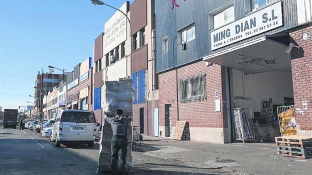 Un hombre carga mercancías frente a un mayorista chino de la calle de Progrés, ayer.