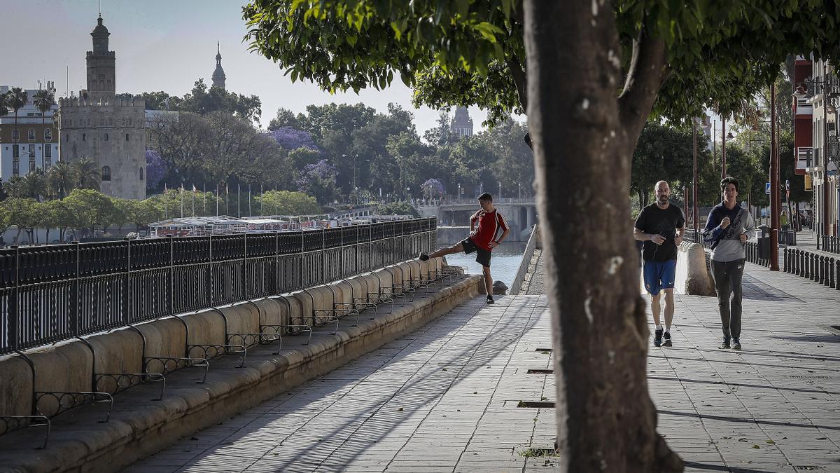 Varias personas hacen deporte en la calle Betis del barrio de Triana de Sevilla, que el alcalde quiere peatonalizar