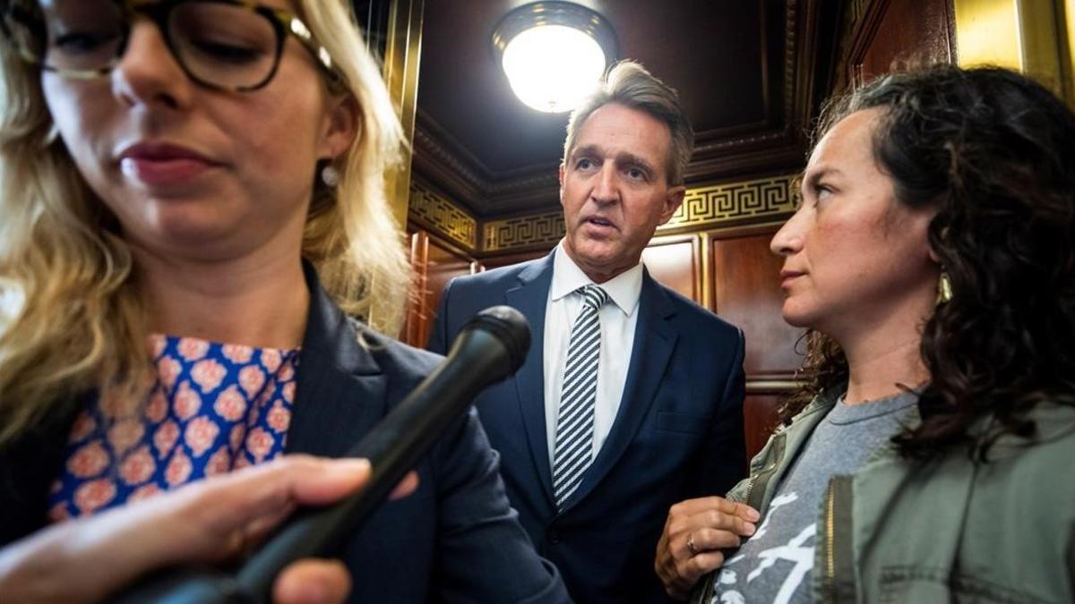 Una presunta víctima de violación, a la derecha, increpa al senador Jeff Flake.