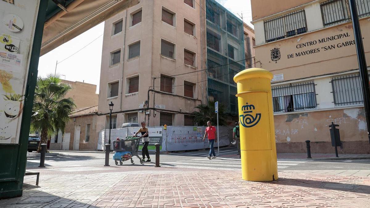 Peatones cruzan la plaza Enrique López Vidal con la calle La Amistad al fondo, en el barrio de San Gabriel de Alicante