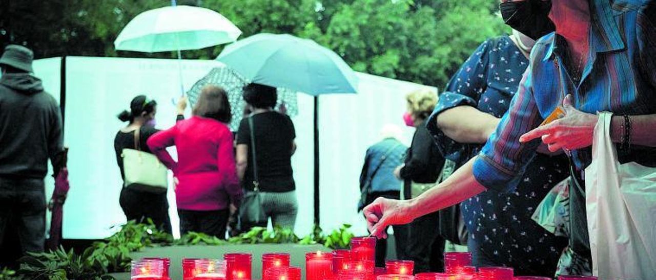 Una mujer enciende una vela, ayer, en la plaza de España de Los Llanos de Aridane.