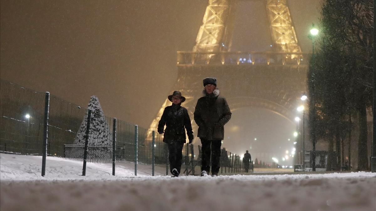 zentauroepp41935466 a couple walk on a snow covered path at the champ de mars ne180207085056