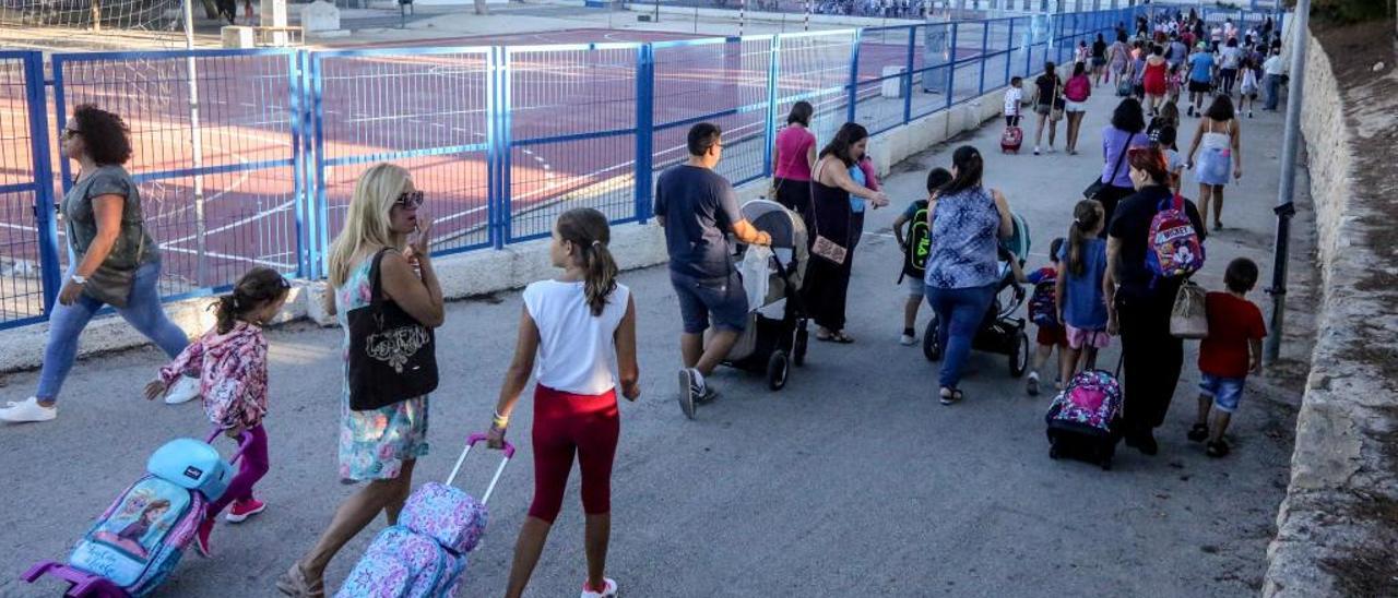 Escolares entran cargados con sus mochilas a uno de los 13 colegios públicos de Benidorm.