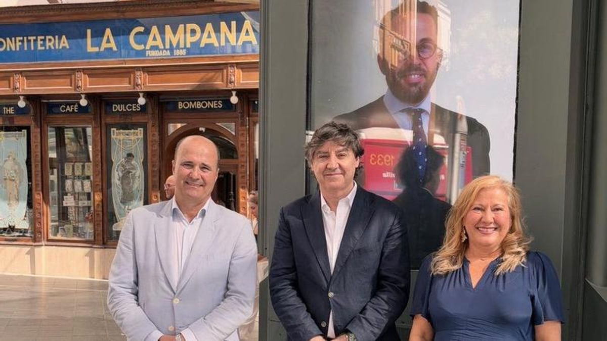 Miembros del colegio de abogados de Sevilla junto al cartel.