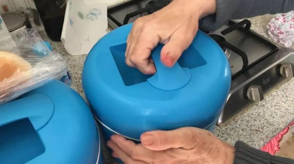 Una anciana usuaria del servicio municipal de comida a domicilio de Calvià abre uno de los tuppers