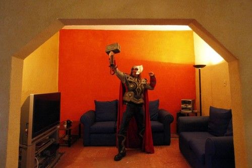 Street artist Ruben Oviedo, dressed as comics superhero Thor, poses for a portrait in the living room of his home in Mexico City