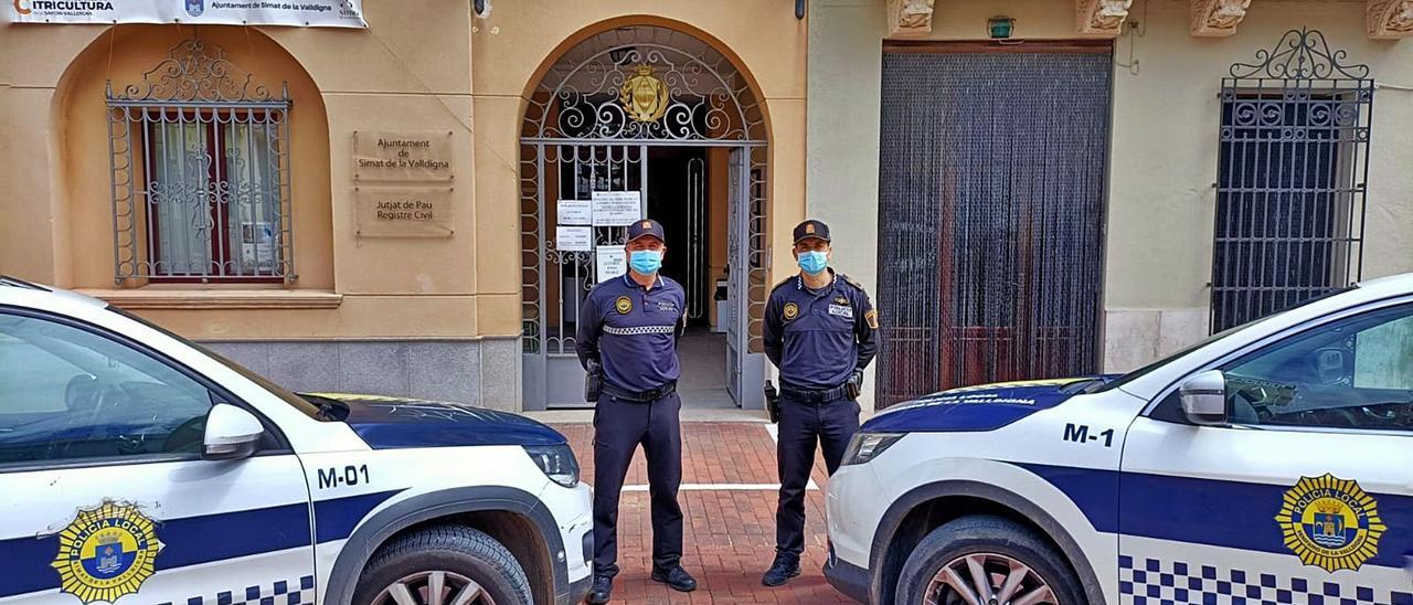 Dos agentes de la Policía Local de Benifairó y Simat,  junto a los vehículos patrulla.